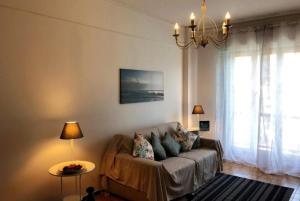 un soggiorno con un divano e un lampadario di Blue Daisy Apartment a Rapallo