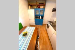 eine kleine Küche mit einem Tisch und einem Kühlschrank in der Unterkunft CASA UNO Heimeliges Chalet mitten in Spiez in Spiez