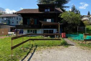 una casa con una valla delante de ella en CASA UNO Heimeliges Chalet mitten in Spiez en Spiez