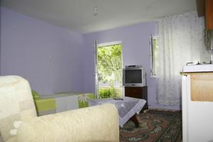sala de estar con sofá y TV en Dogan Pension, en Gokceada Town