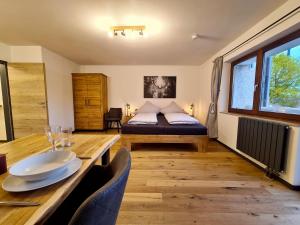 Cette chambre comprend un lit, une table en bois et une salle à manger. dans l'établissement Ferienwohnung Seemöwe, à Radolfzell am Bodensee