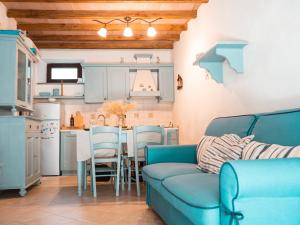 a living room with a blue couch and a kitchen at IL GRECALE - Ca'Mare Apartments in Corniglia