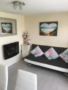 a living room with a couch and a tv at Milas Place in Leysdown-on-Sea