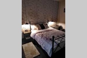 a bedroom with a brick wall and a bed at La Monica 3 - Cazare Straja - Lupeni - Retezat - Parang in Lupeni