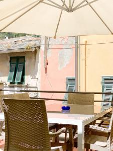 ヴェルナッツァにあるLa Polena Camere Vernazza - Carattino Apartmentのテーブルと椅子、バルコニー(パラソル付)
