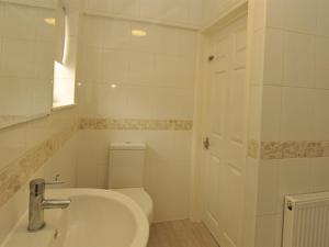 a white bathroom with a toilet and a sink at Gail's Guest House in Barry