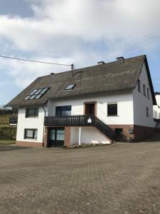 a large white house with a black roof at Ferienwohnung Susanna in Wascheid