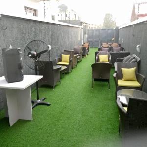 Ocean Park Hotel,Lekki phase 1 في ليكى: صف من الكراسي والطاولات مع سجادة خضراء