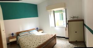 una camera con letto e parete verde e bianca di Appartamento in pieno centro a 100m dal mare a Spotorno