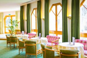 a dining room with tables and chairs and windows at Kurhotel Leonardo in Gmünd