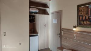 a small kitchen with a refrigerator and a pantry at Gogo's - Γωγώ Rooms & Studios in Nydri