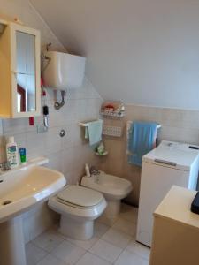 uma casa de banho com um WC branco e um lavatório. em Carmen House em Grottammare