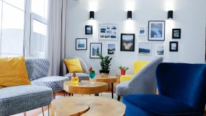 uma sala de estar com mesas e cadeiras azuis e amarelas em Hotel Rezydencja AS & Spa-Najwyżej w Karpaczu em Karpacz
