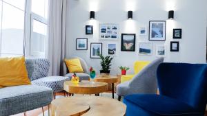 a living room with blue and yellow chairs and tables at Rezydencja AS & Spa-Najwyżej w Karpaczu in Karpacz