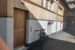 een fiets geparkeerd naast een gebouw met een deur bij Classy Apartment in Interlaken