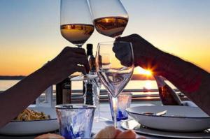 two people are holding glasses of wine on a table at BED&BOAT boatandholiday in Fano +17 photos