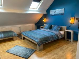 Schlafzimmer mit einem Bett mit blauen Wänden und einem Fenster in der Unterkunft Immaya in Ostende