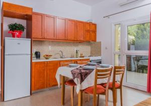 a kitchen with a table and a white refrigerator at Arsinoi Studios and Apartments in Kalamaki +28 photos