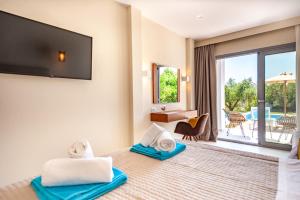 Alonaki Resort في بريفيزا: غرفة فندق بسرير وتلفزيون بشاشة مسطحة