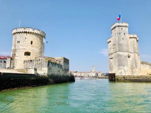 two towers in the water next to a river at Nuit insolite à bord d’un voilier in La Rochelle