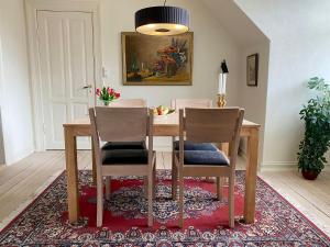 a dining room table with two chairs on a rug at Goodnight Randers in Randers +10 photos