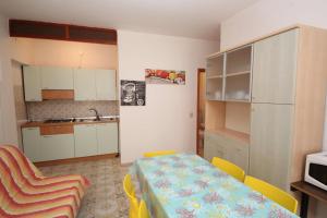 una pequeña cocina con mesa y sillas en una habitación en Villa Manu appartamento 02, en Rosolina Mare