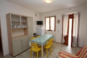 een eetkamer met een tafel en gele stoelen bij Villa Manu appartamento 02 in Rosolina Mare