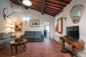 een woonkamer met een bank en een piano bij Casa PRATOLINO in Greve in Chianti