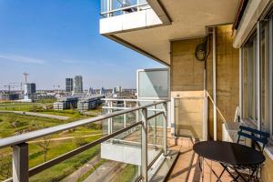 a balcony with a table and a view of a city at New-York style studio (free PARKING/free NETFLIX & sunny terrace) in Antwerp