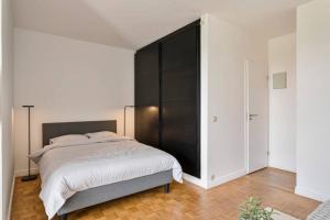 sypialnia z dużym łóżkiem z czarnym zagłówkiem w obiekcie New-York style studio (free PARKING/free NETFLIX & sunny terrace) w Antwerpii