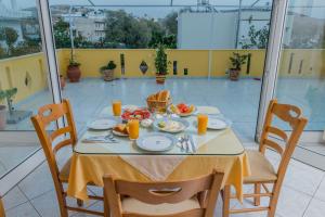 a table with plates of food on a balcony at Arsinoi Studios and Apartments in Kalamaki