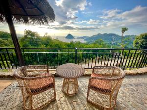 a table and four chairs on a balcony with a view at Elang Hillside Bamboo Villas in Labuan Bajo