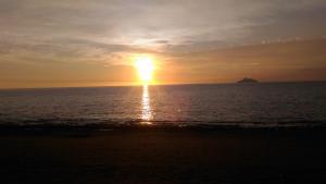 a sunset over the ocean with a island in the distance at Arsinoi Studios and Apartments in Kalamaki