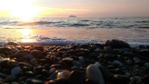 a group of people on the beach at sunset at Arsinoi Studios and Apartments in Kalamaki