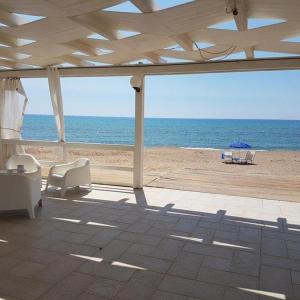 vista su una spiaggia con ombrellone e sedie di COSTA FENICIA RESIDENCE - Aura Club a Scoglitti