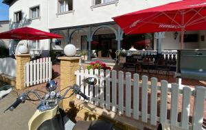 una moto estacionada junto a una cerca blanca y un restaurante en Hotel Altes Kurhaus, en Baabe