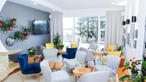 una sala de espera con mesas y sillas azules y amarillas en Hotel Rezydencja AS & Spa-Najwyżej w Karpaczu, en Karpacz