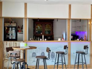a bar with chairs and a table in a restaurant at Hotel Altes Kurhaus in Baabe