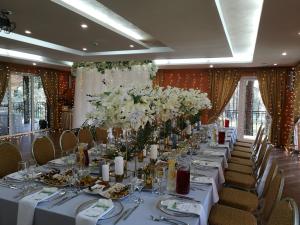 a long table with white flowers in a room at Vila Kelmyne in Molėtai
