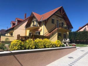 una casa con flores amarillas delante de ella en Laura-haus en Vonyarcvashegy