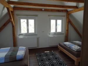 1 dormitorio con 2 camas y 2 ventanas en Fichtelhaisla, en Röslau