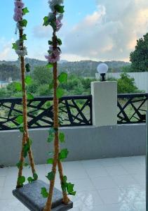 duas flores artificiais estão a crescer numa varanda em بيات للنزل السياحية em Al Qarāḩīn