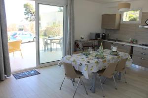 Un comedor con mesa y sillas y una cocina. en Villa Laurum - Giardino degli allori - Castellammare del Golfo - Scopello, en Castellammare del Golfo 23 fotos más