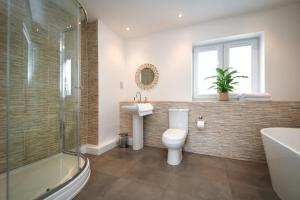 a bathroom with a toilet and a sink and a shower at Lakeside Old Hunstanton in Hunstanton