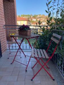 a table and a chair with a potted plant on a balcony at VILLA FERNANDO in Castagnole Lanze