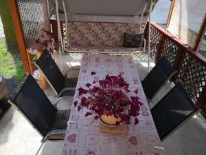a table with a vase of flowers on a balcony at Domboldal Vendégház in Noszvaj