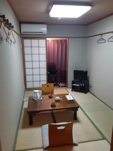 a living room with a table and a room with a chair at OHTO Ryokan in Kyoto