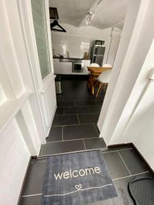 a hallway with a welcome mat on the floor at Ferienwohnung Winterberg Lodge in Winterberg +4 photos