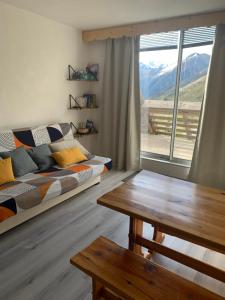 sala de estar con sofá, mesa y ventana en Studio cabine Piau-Engaly au pied des pistes en Aragnouet