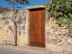 a wooden door on the side of a stone wall at IL Gnejna II in Xagħra